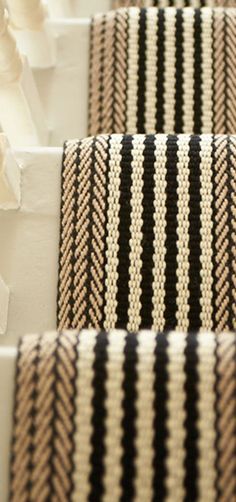 three black and white striped rugs sitting on top of each other in a room