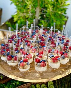 small desserts are arranged on a tray with strawberries and blueberries in them