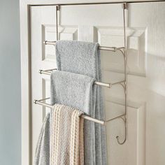 two towels are hanging on a rack in front of a white door with an open window