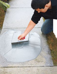 a man kneeling down to put something in the ground with his hand on top of it