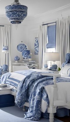 a bedroom with blue and white decor on the walls, windows, and bedding