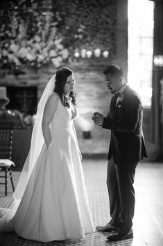 a bride and groom standing in front of each other at their wedding ceremony, with the bride holding her hand out