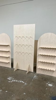 three unfinished wooden bookshelves sitting next to each other on top of a floor