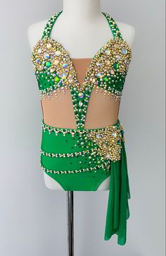 a green and gold costume on a mannequin headdress with beading