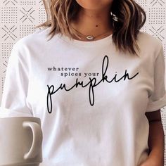 Who Else Loves A Good Pumpkin Spice Latte? This Whatever Spices Your Pumpkin Graphic Is The Perfect Top For This Upcoming Fall, It Features A White Background With Black Lettering. Bust Lying Flat: S-18.5in, M-20in, L-22in Length Lying Flat: S-24.5in, M-26.5in, L-28.5in Material: 100% Cotton Simple White Top With Text Print, Simple White Tops With Text Print, Basic White T-shirt For Fall, White Tops With Text Print For Fall, White Text Print Tops For Fall, Pumpkin Graphic, Best Pumpkin, Fall Tee, Pumpkin Spice Latte