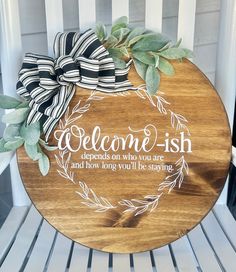 a wooden sign that says, welcome - ish with leaves on it and a bow