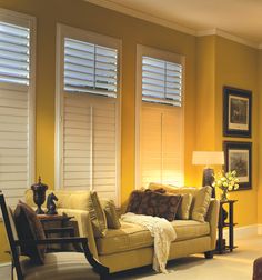 a living room filled with furniture and windows covered in shades of light yellow paint on the walls