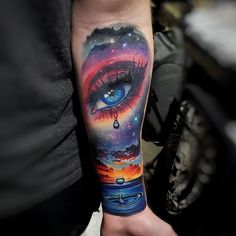 a person with a tattoo on their arm has an eye and stars in the sky