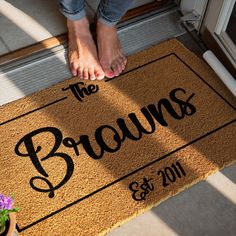 a person standing on a door mat that says the browns and is next to a potted plant