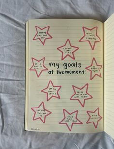 an open notebook with writing on it that says, my goals at the moment