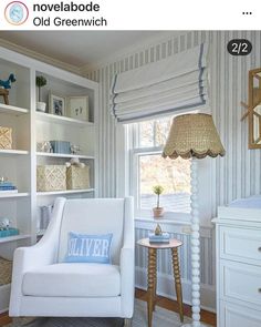 a white chair sitting in front of a window next to a shelf filled with books