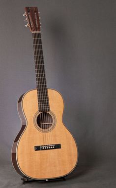 an acoustic guitar sitting on top of a stand