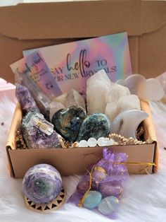 a box filled with lots of different types of rocks and stones on top of a white blanket