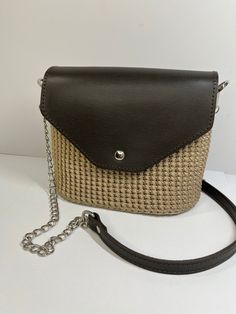 This bag is made of polyester cord with genuine leather cover and base. Closes with a magnetic button. Shoulder strap is made of genuine leather and metal chain. Inside the bag there is a satin lining. Dimensions: Length 22 cm Width 17 cm Depth 11 cm Shoulder strap - 120 cm This bag is in stock and will be shipped to you within 1-2 bussiness days. Beige Straw Bag With Chain Strap For Everyday Use, Natural Shoulder Bag With Chain Strap For Everyday Use, Everyday Straw Shoulder Bag With Chain Strap, Chic Crochet Bag With Chain Strap For Everyday, Chic Handmade Crossbody Bucket Bag, Trendy Crochet Bag With Detachable Strap, Brown Vacation Bag With Chain Strap, Brown Bags With Chain Strap For Vacation, Brown Shoulder Bag With Chain Strap For Vacation