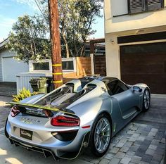 a silver sports car parked in front of a house