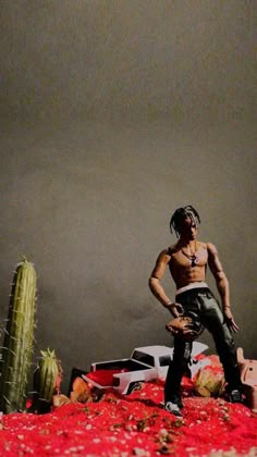 a man standing on top of a bed next to a cactus