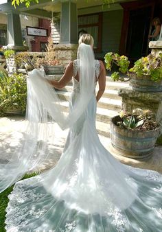 a woman in a wedding dress is standing outside