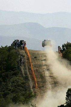 the truck is driving down the hill with dust coming out of it's tires