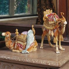 a figurine of a camel and a manger scene on a table in front of a mirror