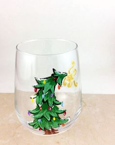 a glass with a christmas tree painted on it