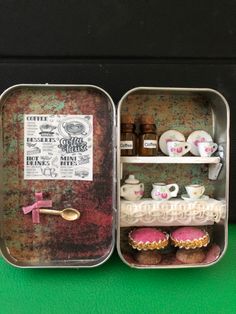 two tins filled with pastries on top of a green table