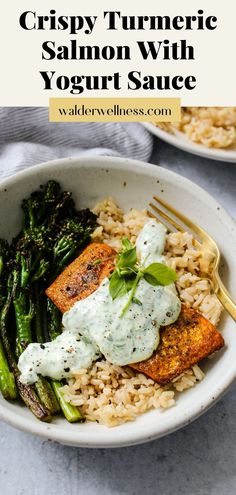 a white bowl filled with rice, asparagus and salmon topped with sour cream sauce