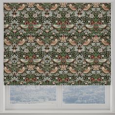 a window with a green and red patterned blind in front of a window sill