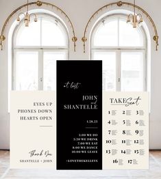 a black and white wedding table plan is displayed in front of two windows with gold trimming