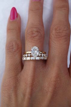 a woman's hand with two wedding rings on it