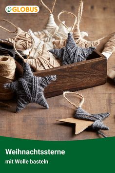 a wooden box filled with twine and star shaped ornaments on top of a table