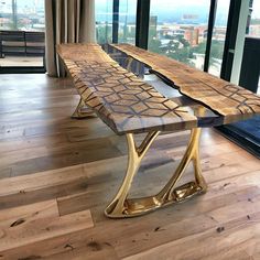 a wooden bench sitting on top of a hard wood floor next to a large window