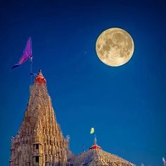 the full moon shines brightly above an ornate building