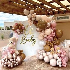 a baby shower with balloons, teddy bears and other items on the ground in front of it