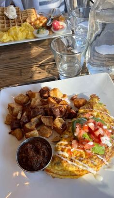 an omelet and some potatoes on a white plate