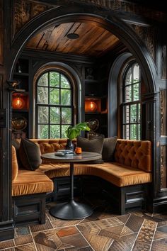 a room with arched windows, two couches and a table in the middle of it