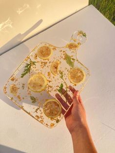 a person holding a tray with lemons on it and other food items in the background