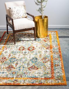 a chair sitting on top of a rug next to a vase with a plant in it