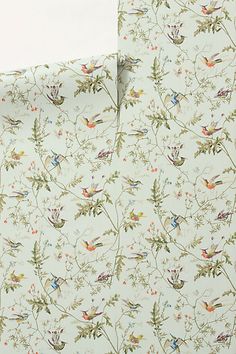 two sheets with birds and flowers on them, one is white and the other is blue