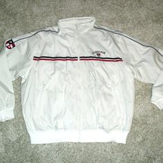 Brand New Retails For $275 Mens Sz. Xl Polo Full Zip Polyester Jacket. The Front Has The Sewn On Embroidered U.S. Polo Assn. 1890 With The Usa Flage On It. The Right Sleeve Has The Sewn On P Star And Stipes Shield Logo On It. The Bottom Of The Jacket Has Two Hand Pockets. The Hood Is In The Zip Up Part Of The Collar. So If Not Using The Hood It Rolls Up Into The Zip Collar. Made Of 100% Polyester Material. It Measures From Top Of Collar To Bottom Of Shirt Is 31 Inches And From Armpit To Armpit I Classic White Sport Coat For Winter, Classic White Outerwear For Outdoor, Classic White Outdoor Outerwear, White Half-zip Casual Track Jacket, Vintage White Track Jacket, Moisture-wicking Four-way Stretch Collared Polo Shirt, White Moisture-wicking Collared Polo Shirt, Sports Collared Polo Shirt With Moisture-wicking Fabric, White 4-way Stretch Polo Shirt