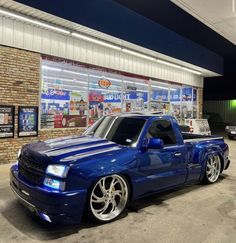 a blue truck parked in front of a store