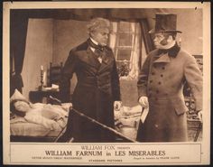 an old black and white photo of two men in top hats standing next to each other