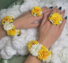 two hands with yellow and white flowers on them