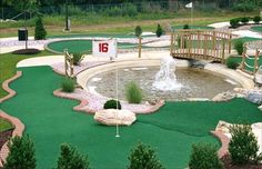 miniature golf course with water fountain and bridge