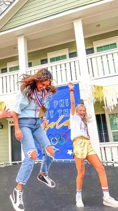 two girls jumping in the air with their hands up