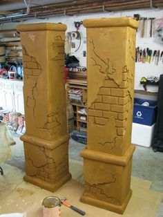 two tall wooden pillars sitting on top of a floor next to each other in a garage