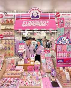 two people standing in front of a store display filled with toys and merchandise for sale