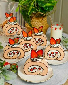 there are many plates that have strawberries in the shape of rolls on them,