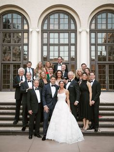 a large group of people in tuxedos posing for a photo on some steps