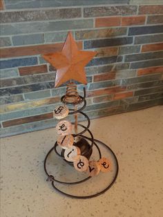 a star on top of a metal stand with letters and numbers in the shape of a christmas tree