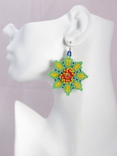 Huichol Mexican Bead Earrings - Yellow-green seed bead earring- Vibrant Dangle Seed Bead Floral Jewelry, Flowered Mexican Huichol earrings Elegant, classy and vibrant artistry collection of handmade Huichol bead earrings, available in medley of vivid and delightful colors. Each pair of this floral seed bead earring is a testament to the rich cultural tapestry of the Huichol people, intricately handcrafted to bring a splash of spring into  summer brilliance to your attire, no matter the season. T Traditional Green Flower Earrings, Green Flower Beaded Earrings Gift, Handmade Green Flower Beaded Earrings, Handmade Green Beaded Flower Earrings, Green Flower Beaded Earrings For Gift, Green Dangle Jewelry With Bead Caps, Bohemian Green Flower Beaded Earrings, Green Bohemian Flower Beaded Earrings, Green Bohemian Beaded Flower Earrings